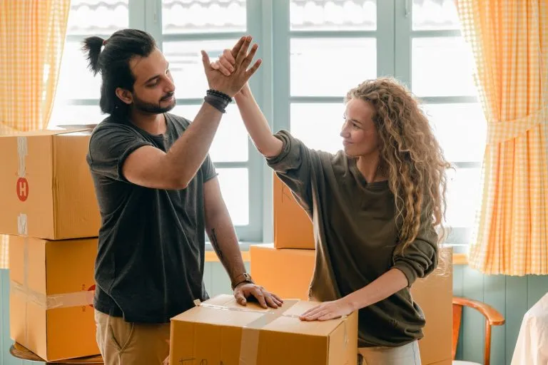Pareja empacando sus pertenencias después de averiguar cómo obtener un crédito hipotecario en Creditaria
